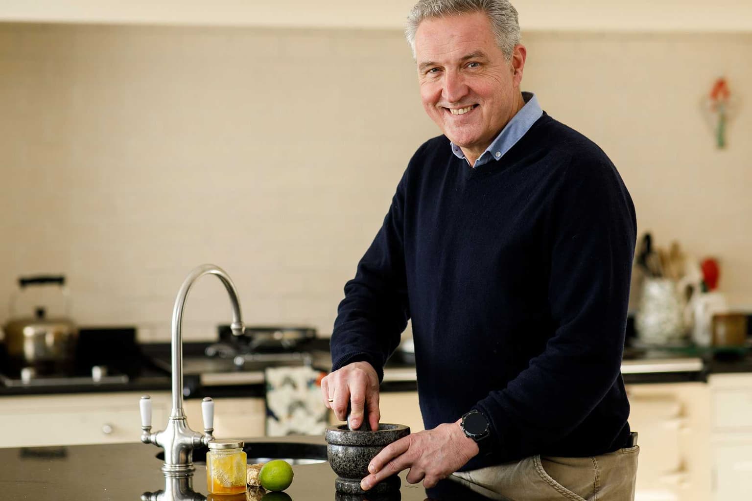 Dr Oscar O’Duchon grinding herbs with a mortar and pestle in his kitchen